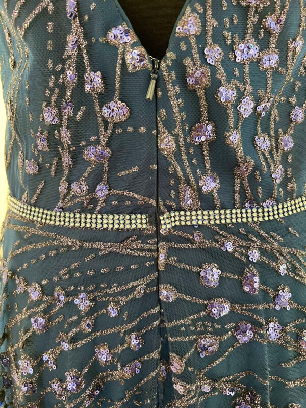 Robe de soirée longue bleu marine ornée de sequins scintillants, avec décolleté en V et silhouette fluide.