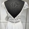 Robe de mariée avec bustier en tulle illusion, broderies florales blanches, décolleté en dentelle et manches cap.