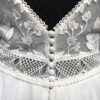 Robe de mariée avec bustier en tulle illusion, broderies florales blanches, décolleté en dentelle et manches cap.