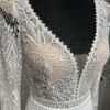 Robe de mariée Tina d’Angeola en tulle illusion avec broderies florales, décolleté en dentelle et ceinture géométrique.