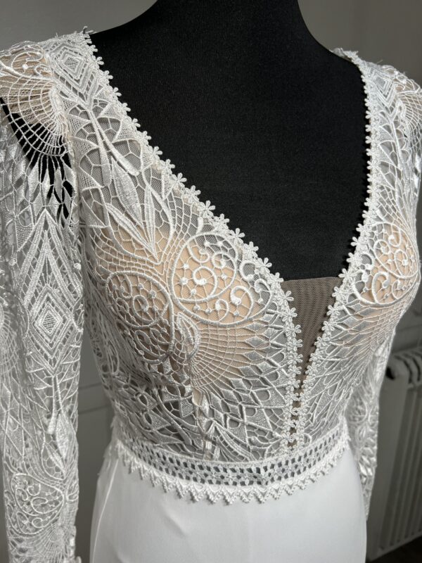 Robe de mariée Tina d’Angeola en tulle illusion avec broderies florales, décolleté en dentelle et ceinture géométrique.