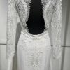 Robe de mariée Tina d’Angeola en tulle illusion avec broderies florales, décolleté en dentelle et ceinture géométrique.