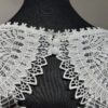 Robe de mariée Tina d’Angeola en tulle illusion avec broderies florales, décolleté en dentelle et ceinture géométrique.