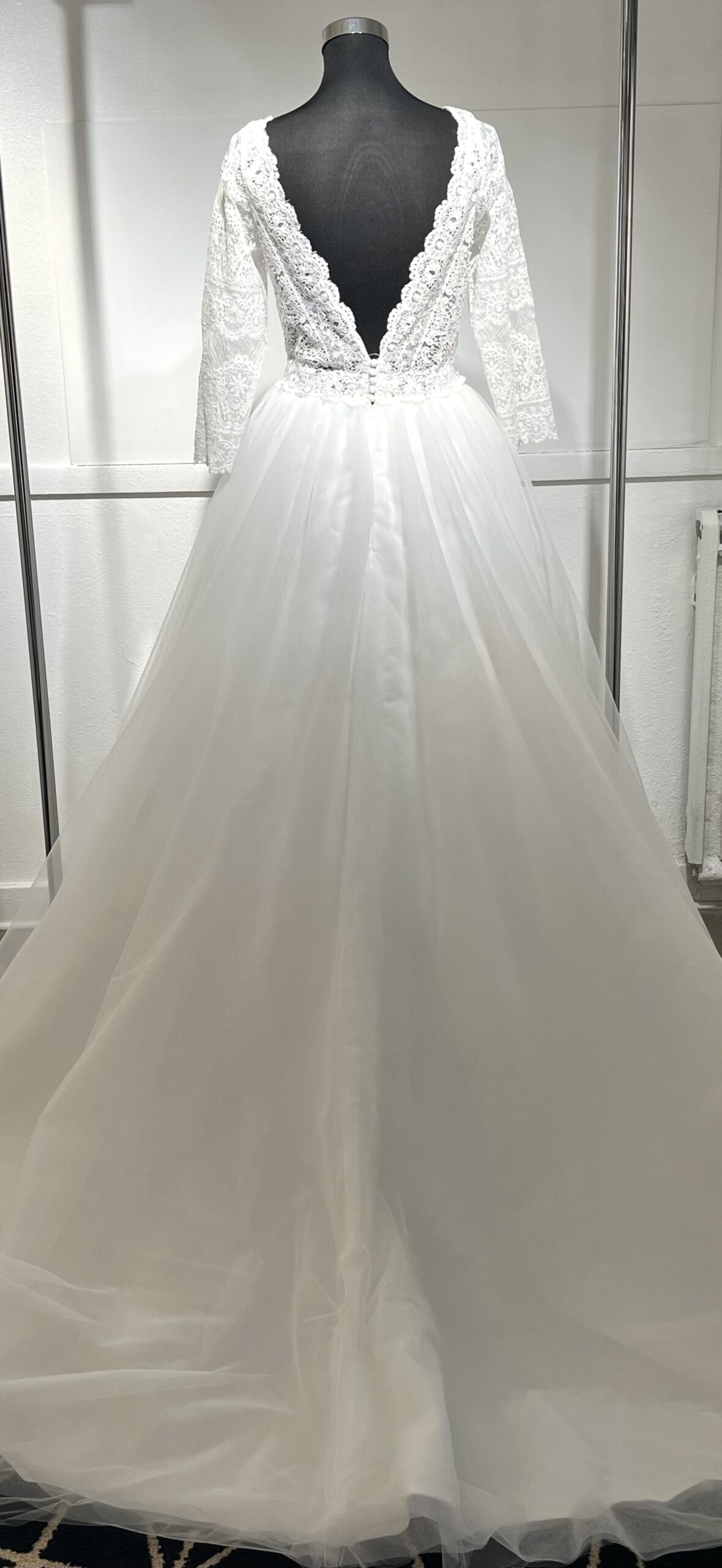 Robe de mariée élégante, manches longues en dentelle, décolleté en V, jupe en tulle fluide.