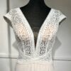 Robe de mariée moderne avec bustier en dentelle blanche, manches courtes, décolleté en V et jupe longue fluide en tissu vaporeux