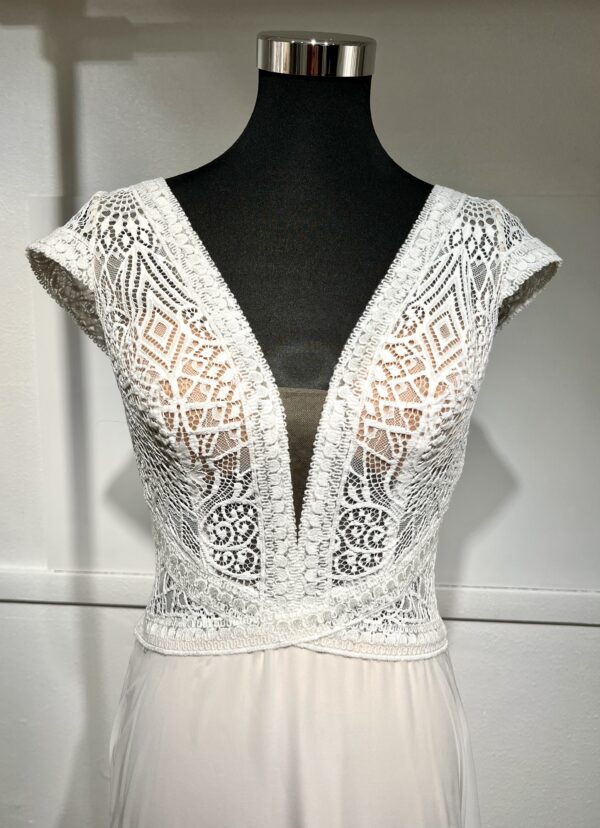 Robe de mariée moderne avec bustier en dentelle blanche, manches courtes, décolleté en V et jupe longue fluide en tissu vaporeux
