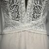 Robe de mariée moderne avec bustier en dentelle blanche, manches courtes, décolleté en V et jupe longue fluide en tissu vaporeux
