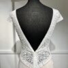 Robe de mariée moderne avec bustier en dentelle blanche, manches courtes, décolleté en V et jupe longue fluide en tissu vaporeux