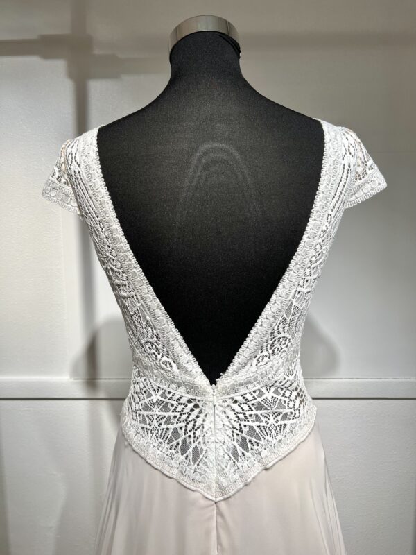 Robe de mariée moderne avec bustier en dentelle blanche, manches courtes, décolleté en V et jupe longue fluide en tissu vaporeux