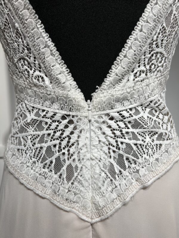 Robe de mariée moderne avec bustier en dentelle blanche, manches courtes, décolleté en V et jupe longue fluide en tissu vaporeux