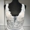 La robe de mariée Tiara avec décolleté en V, bustier en dentelle, ceinture perlée et jupe fluide en satin