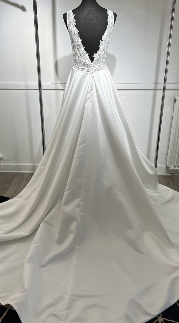 La robe de mariée Tiara avec décolleté en V, bustier en dentelle, ceinture perlée et jupe fluide en satin