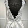 La robe de mariée Tiara avec décolleté en V, bustier en dentelle, ceinture perlée et jupe fluide en satin