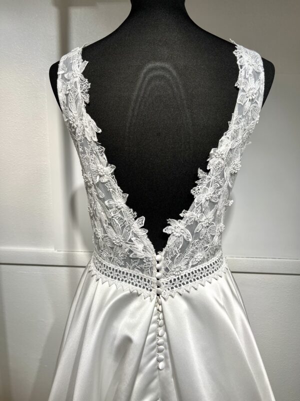 La robe de mariée Tiara avec décolleté en V, bustier en dentelle, ceinture perlée et jupe fluide en satin