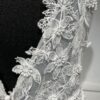 La robe de mariée Tiara avec décolleté en V, bustier en dentelle, ceinture perlée et jupe fluide en satin