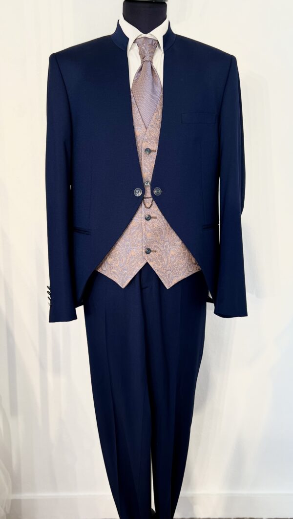 Costume de marié Enzo Romano trois pièces bleu marine avec col officier, gilet assorti à motifs et pantalon ajusté.