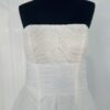 Robe de mariée bustier en tulle blanc, corsage texturé, volants superposés et base légèrement transparente, pour une silhouette aérienne et romantique.