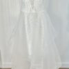 Robe de mariée bustier en tulle blanc, corsage texturé, volants superposés et base légèrement transparente, pour une silhouette aérienne et romantique.