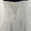 Robe de mariée bustier en tulle blanc, corsage texturé, volants superposés et base légèrement transparente, pour une silhouette aérienne et romantique.