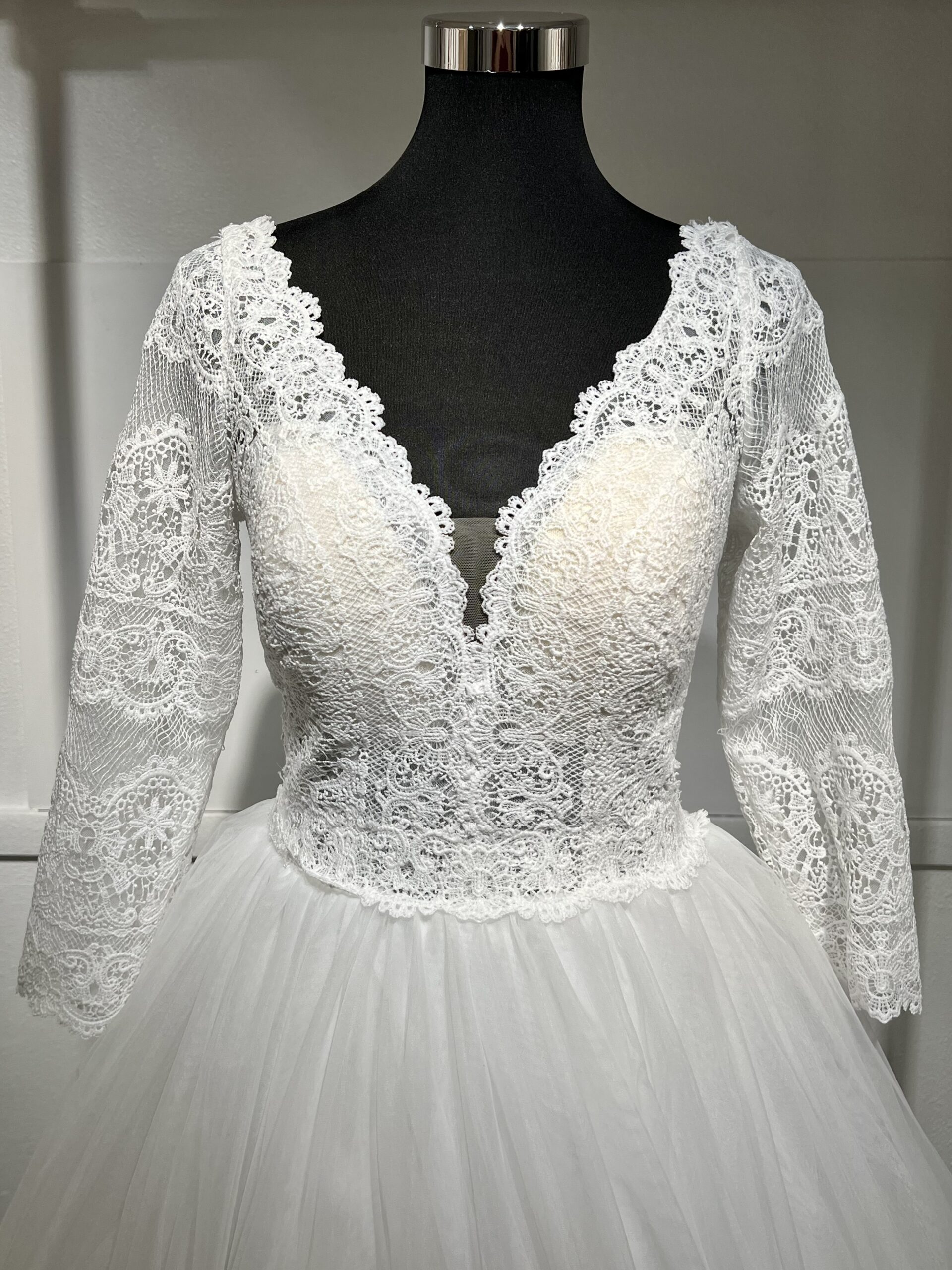 Robe de mariée élégante, manches longues en dentelle, décolleté en V, jupe en tulle fluide.