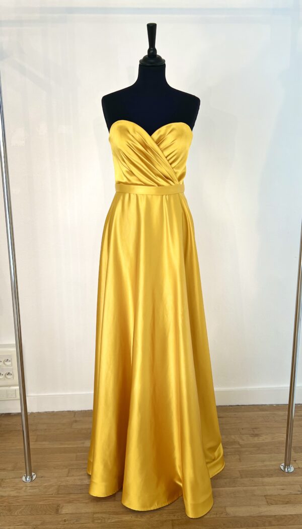 Robe de cocktail longue en satin jaune, sans manches, ajustée au buste avec une coupe fluide et un tombé élégant jusqu’au sol.