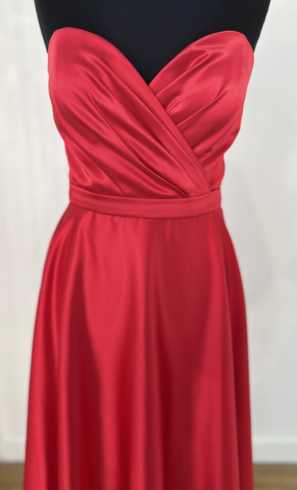 Robe de cocktail courte en satin rouge, avec un bustier cœur drapé et une ceinture fine, offrant une coupe fluide et moderne.