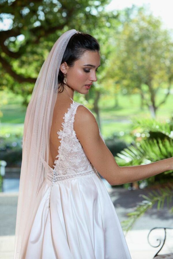 La robe de mariée Tiara avec décolleté en V, bustier en dentelle, ceinture perlée et jupe fluide en satin
