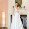La robe de mariée Tiara avec décolleté en V, bustier en dentelle, ceinture perlée et jupe fluide en satin