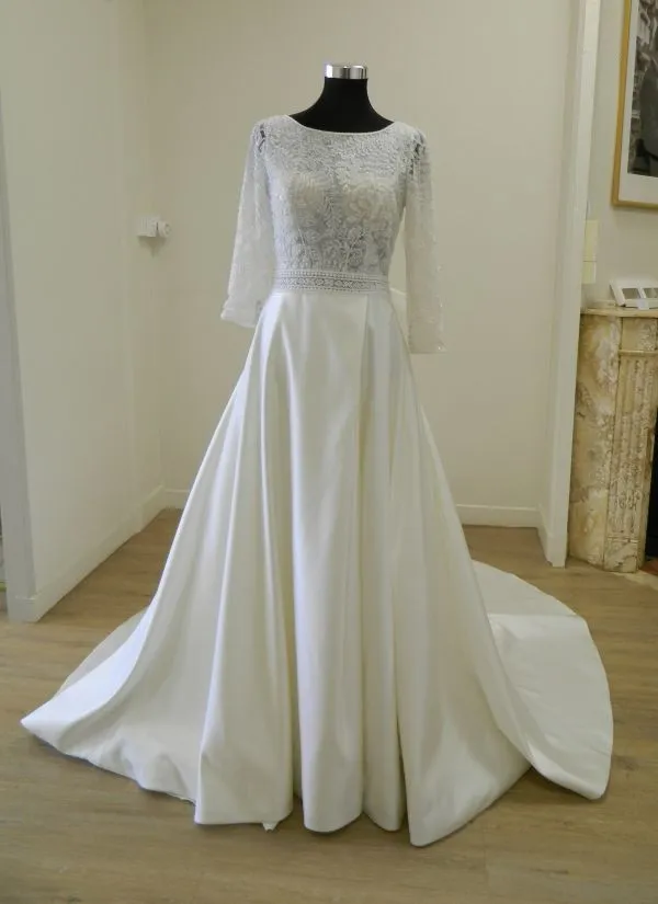 Robe de mariée princesse en mikado Suna par Aire Barcelona présentée de face sur mannequin en boutique.