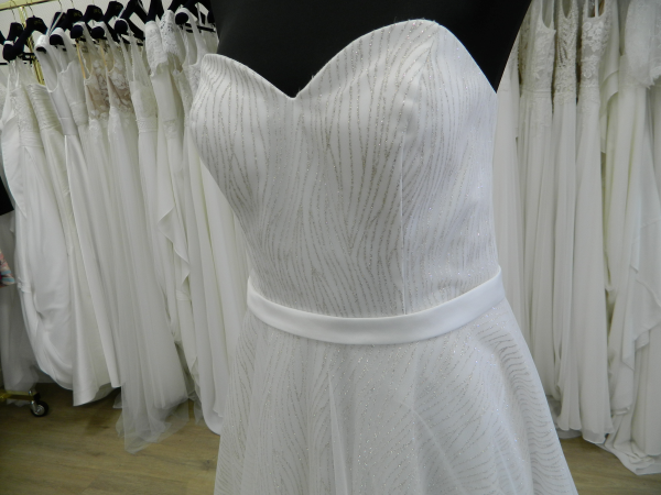 Gros plan du bustier en cœur drapé et de la ceinture en satin de la robe de mariée RP082H Créatif Paris dans la boutique de Tours.