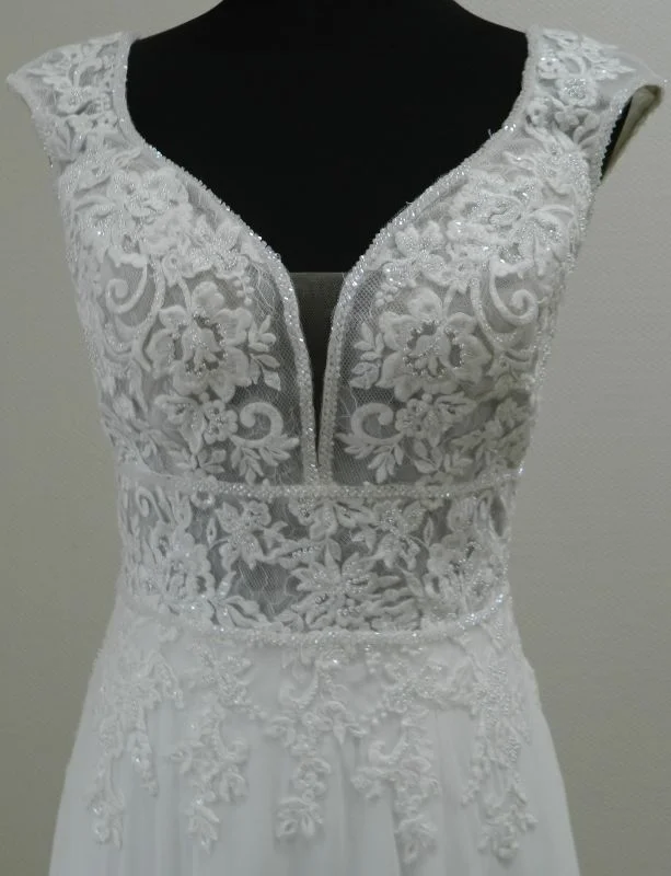 Gros plan technique de face sur le bustier en dentelle florale pailletée, le décolleté plongeant en V et les mancherons de la robe de mariée 44275 Justin Alexander.
