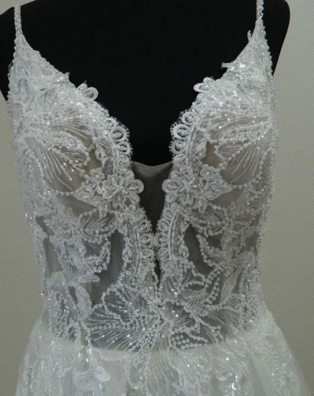 Gros plan technique de face sur le bustier en dentelle florale à sequins scintillants et le décolleté plongeant en V de la robe de mariée princesse 23236 Très Chic.