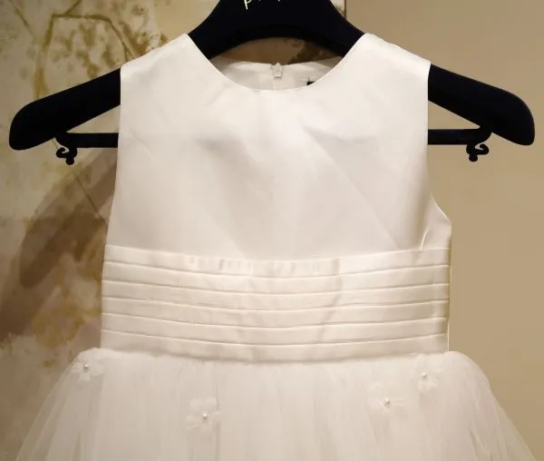 Gros plan sur le bustier en satin, la ceinture plissée et les fleurs perlées en relief de la robe fillette Tiffany au showroom de Poitiers.