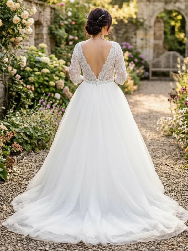 Vue de dos d'une mariée portant la robe princesse 23711 de One and Only, mettant en valeur le décolleté en V plongeant en dentelle à manches trois-quarts et la traîne en tulle.