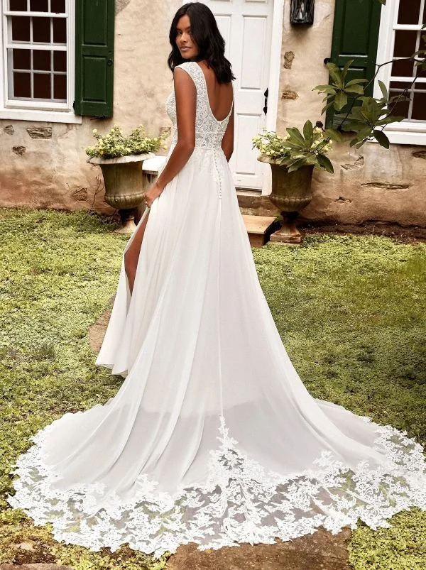 Vue de dos d'une mannequin portant la robe de mariée trapèze 44275 de Justin Alexander, dévoilant un dos nu arrondi en dentelle et une longue traîne fluide bordée de guipure.