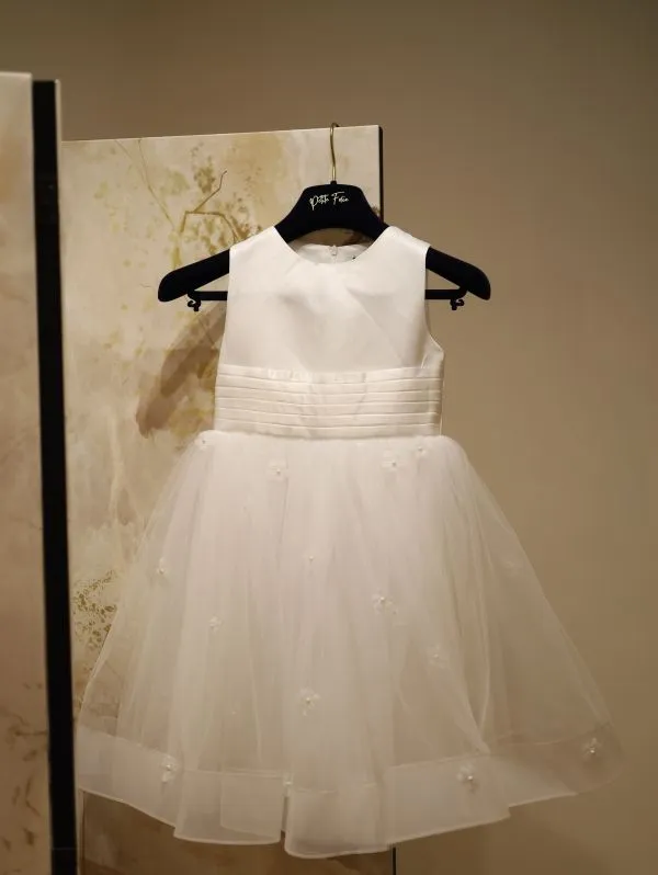 Robe de cortège fillette blanche Tiffany de Petite Folie sur cintre, vue de face entière au showroom de Saint-Georges-lès-Baillargeaux près de Poitiers.
