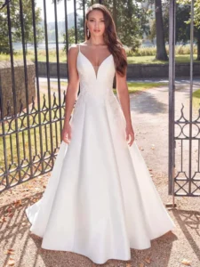 Portrait en gros plan d'une mariée portant une robe de mariée avec bretelles fines et broderies florales