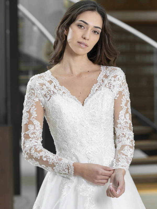 Gros plan sur le bustier et les manches longues en dentelle perlée de la robe de mariée princesse Lovely 23419.