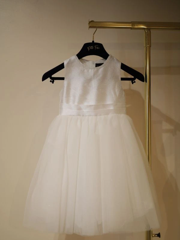 Robe fillette de cérémonie blanche modèle Anouk par Petite Folie sur cintre, vue de face entière au showroom de Saint-Georges-lès-Baillargeaux près de Poitiers.