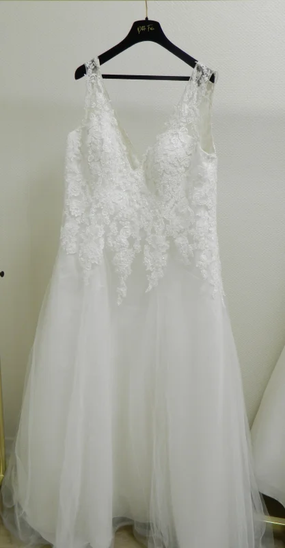 Robe de mariée princesse Shaily vue de face, suspendue sur portant, détails de dentelle sur le bustier