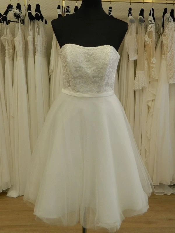 Robe de mariée courte modèle NC2924 par Nana Couture en blanc pur, vue de face entière présentée sur un mannequin de couture de face dans un showroom.