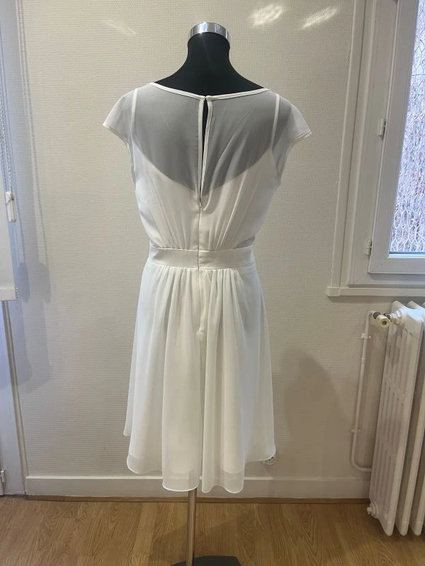Robe de mariée courte blanche modèle NY2779 de Fashion New York en taille 46, vue de dos entière sur mannequin de couture au showroom.