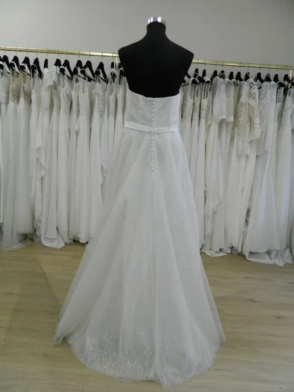 Vue de dos de la robe de mariée RP082H Créatif Paris sur mannequin de couture, montrant le dos droit boutonné et la traîne en tulle dans le showroom de Tours