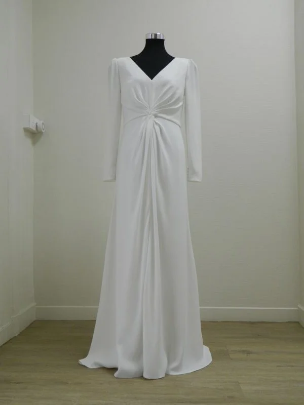Robe de mariée fourreau en crêpe blanc Salvia d'Aire Barcelona avec manches longues et drapé à la taille, vue de face entière au showroom de Tours.