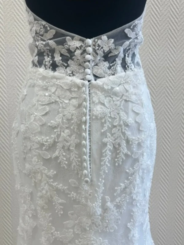 Gros plan sur le dos de la robe de mariée sirène JASMIN, mettant en évidence la rangée de boutons perlés et les détails sophistiqués de la dentelle brodée.