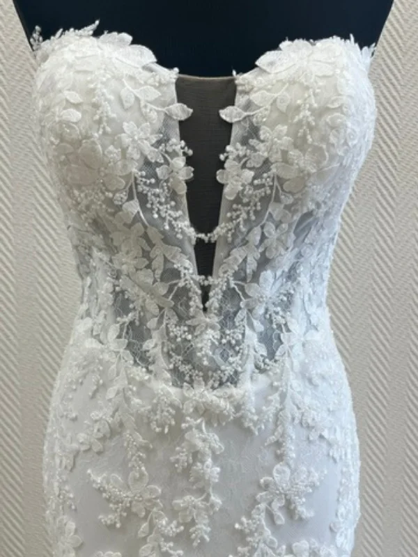Gros plan sur le bustier de la robe de mariée sirène JASMIN : décolleté plongeant, dentelle florale perlée et finitions en sequins.