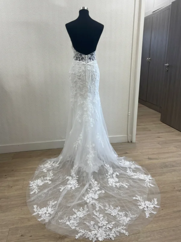 Vue de dos sur portant de la robe de mariée sirène JASMIN, mettant en avant le dos nu, la boutonnière délicate et la traîne en tulle ornée de dentelle.