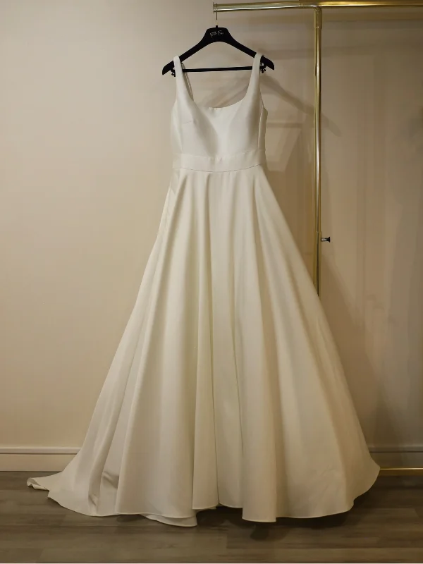 Robe de mariée princesse modèle Hollie par Adriana Alier, en Mikado ivoire naturel, vue de face sur cintre avec un bustier architectural épuré.