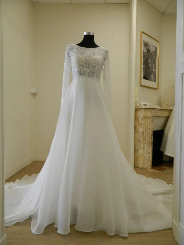 Robe de mariée princesse Sira d'Aire Barcelona en organza et dentelle, vue de face entière sur mannequin au showroom de Tours.