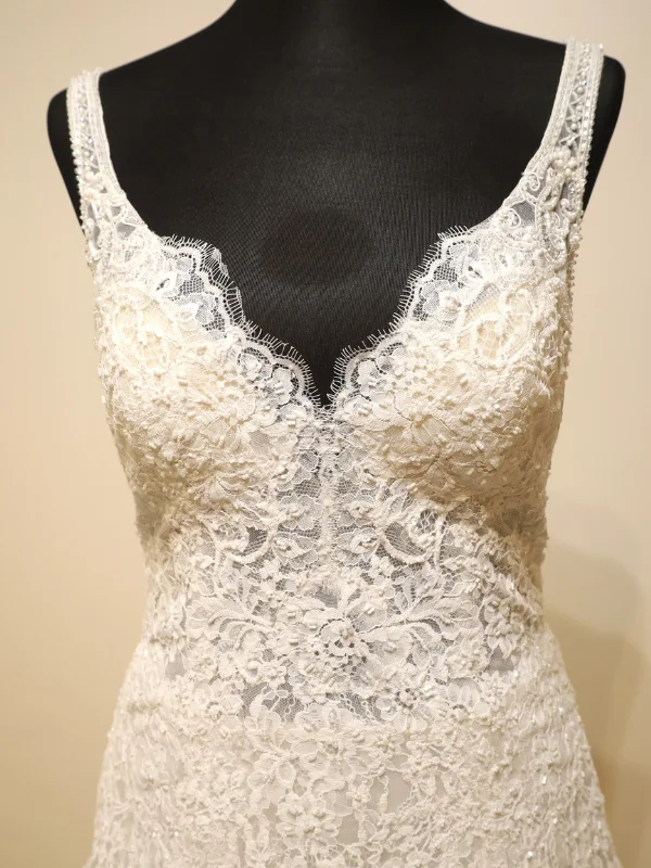 Gros plan sur le bustier en dentelle florale perlée de la robe de mariée princesse modèle Concord par Rosa Clara, détails des finitions sur portant.